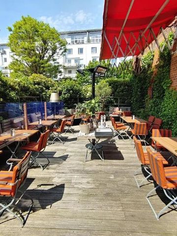 Sonnige Terrasse mit Sitzgelegenheiten und grüner Umgebung
