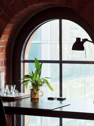 Gemütlicher Bereich mit Ziegelwand und großem Fenster