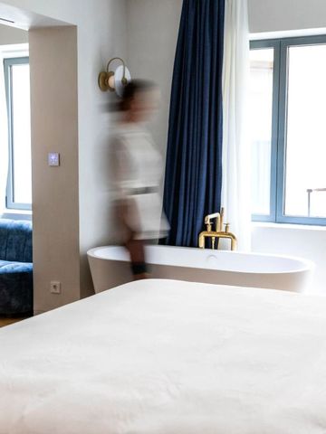 Hotelzimmer mit moderner Einrichtung und einer freistehenden Badewanne.