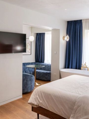 Helles Zimmer mit moderner Einrichtung und blauen Akzenten.