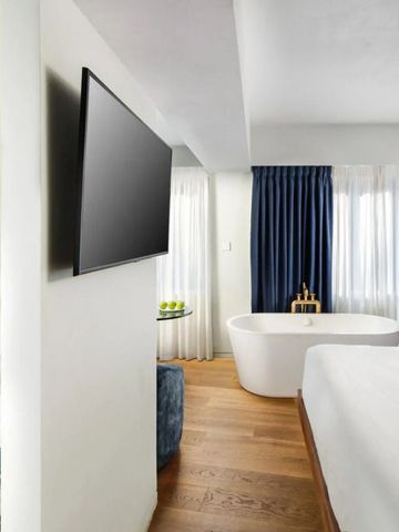 Luxuriöses Hotelzimmer mit freistehender Badewanne und großem Bett