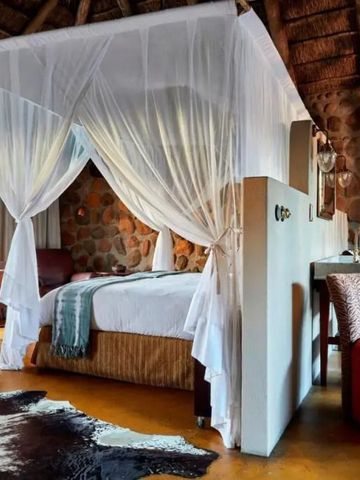 Zimmer mit Baldachinbett und steinverkleideten Wänden