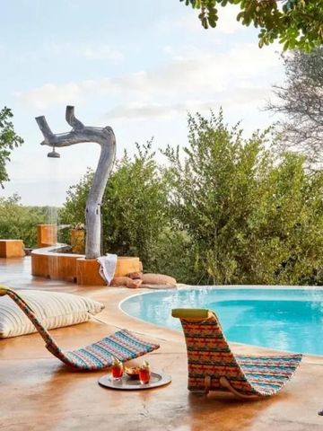 Infinity-Pool mit Liegen und atemberaubender Aussicht auf die Savanne
