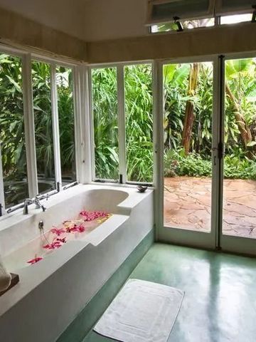Badewanne mit Blüten und direktem Zugang zum Garten