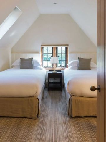 Helles Schlafzimmer mit zwei Einzelbetten und Dachfenster im Gidleigh Park Hotel