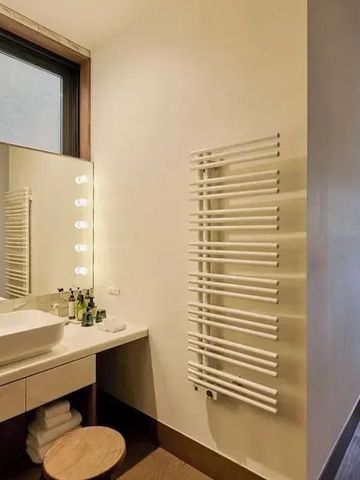 Modernes Badezimmer mit großem Spiegel und Waschbecken sowie Handtuchhalter