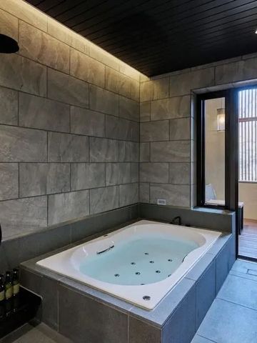 Modernes Badezimmer mit eingelassener Whirlpool-Badewanne aus Stein