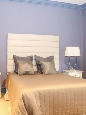 Schlafzimmer mit Doppelbett und eleganter Beleuchtung.