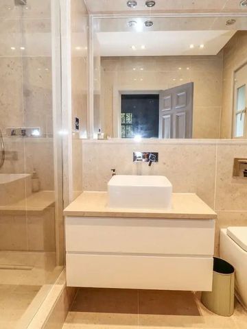 Modernes Badezimmer mit eleganter Dusche und Waschbeckenbereich.