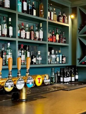 Gut bestückte Hotelbar mit Flaschen und Zapfhähnen.
