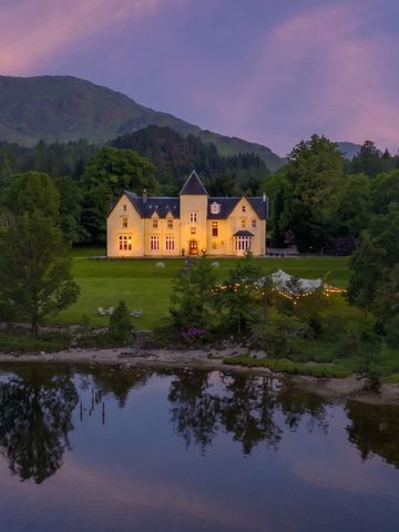 Schönes Hotelgebäude in idyllischer Landschaft am Abend mit beleuchteten Fenstern