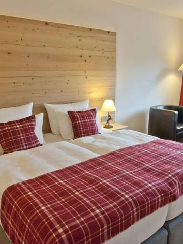 Einladendes Doppelzimmer mit Holzdekor und roten Akzenten