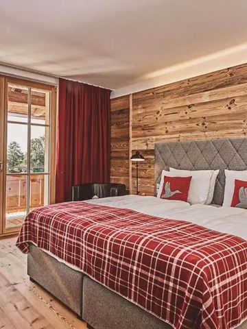 Helles Schlafzimmer mit Holzakzentwand und Panoramafenstern