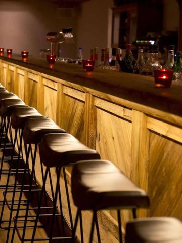 Elegante Hotelbar mit moderner Beleuchtung und langen Holztresen