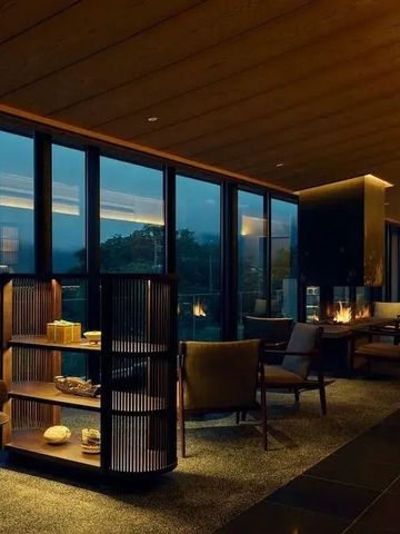 Elegante Lounge mit Panoramablick im Abendlicht und modernem Kamin