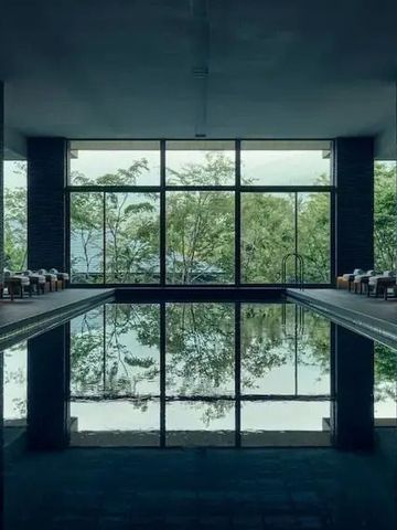 Indoor-Pool mit großen Glasfenstern und Waldsicht