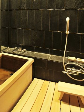 Luxuriöses Badezimmer mit Holzbadewanne in traditionellem japanischen Stil