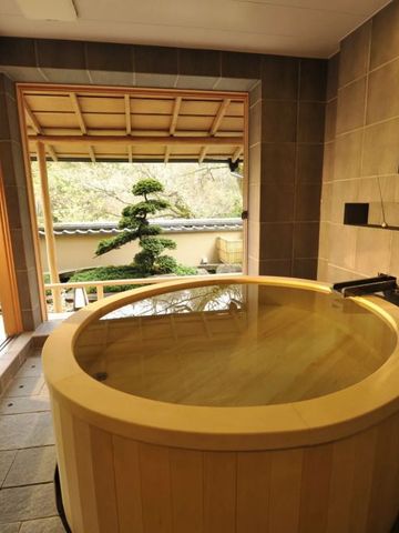 Runde Holzbadewanne mit Gartenblick