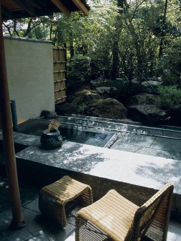 Privater Outdoor-Onsen im Garten von Bäumen umgeben
