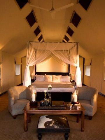 Luxus-Zelt-Suite mit Himmelbett und stilvollen Sesseln im Gorah Elephant Camp