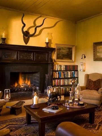 Gemütliche Lounge mit Kamin und Bücherregalen im traditionellem Stil