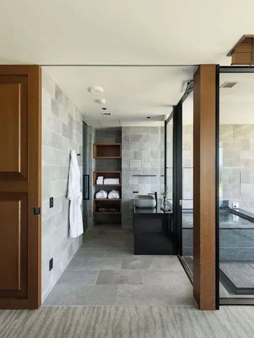 Modernes Badezimmer mit Glaswand und hochwertigen Armaturen