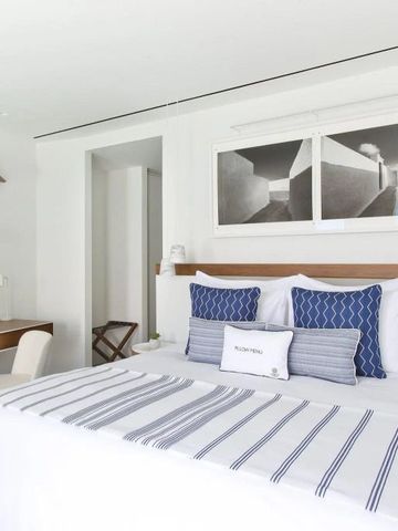 Helles Schlafzimmer mit blauen Akzenten und einem Schreibtischbereich