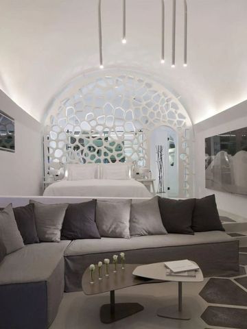 Modernes Hotelzimmer mit großem Sofa, dekorativem Bett und futuristischer Wandgestaltung