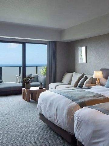 Elegantes Zimmer mit großem Fenster und Blick aufs Meer, moderne Einrichtung.