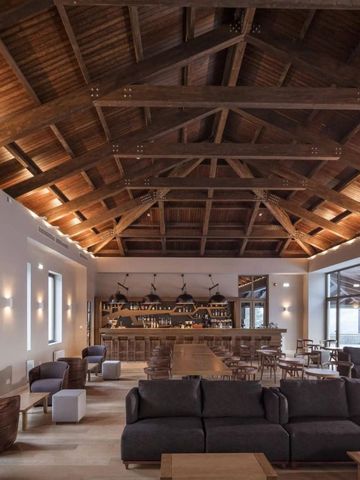 Elegante Hotellobby mit Holzbalkendecke und bequemen Sitzmöbeln.