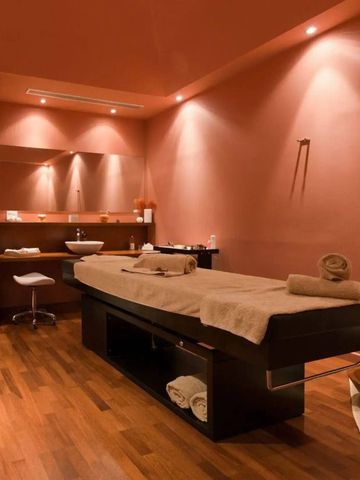 Wellnessraum im Hotel mit Massageliege und warmen Lichttönen.