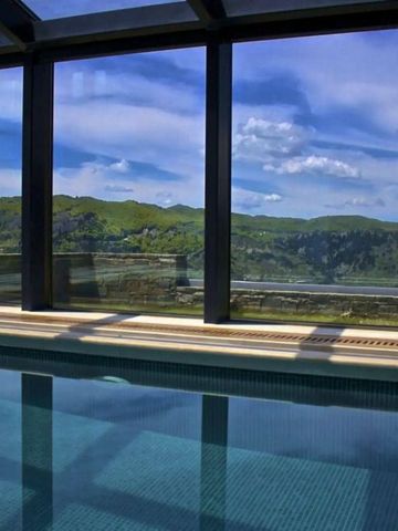 Infinity-Pool mit Glasfenstern und Blick auf malerische Berge