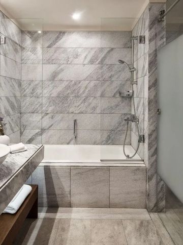 Elegantes Bad mit stilvollem Marmor und begehbarer Dusche