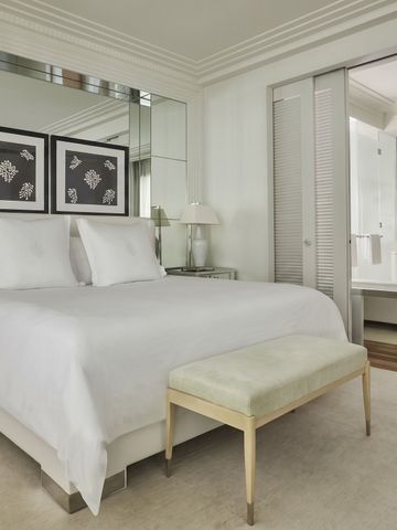 Großes Schlafzimmer in neutralen Tönen mit Fenster und gemusterten Wandbildern