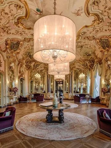 Opulenter Ballsaal mit aufwändiger Decke und luxuriösen Möbeln.