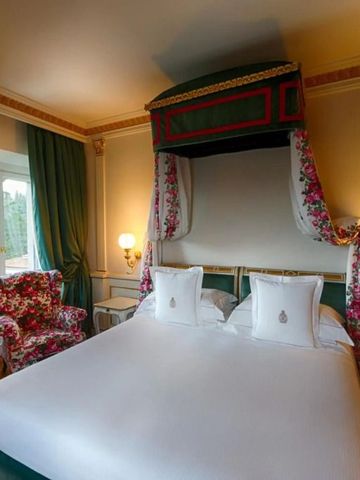 Luxuriöses Gästezimmer mit grünem Baldachinbett und eleganter Einrichtung.
