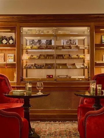 Gemütliche Lounge mit roten Sesseln und gut gefülltem Bücherregal