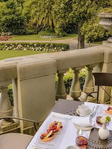 Terrasse mit Blick auf gepflegten Garten beim Frühstück