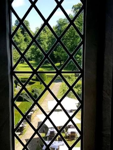 Blick aus einem Fenster auf gepflegten Garten mit Springbrunnen
