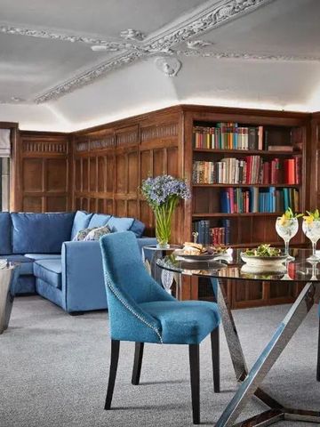 Gemütliche Lounge mit blauer Sofalandschaft und Bücherwand
