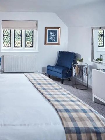 Helles Schlafzimmer mit eleganter Dekoration und Sitzgelegenheiten