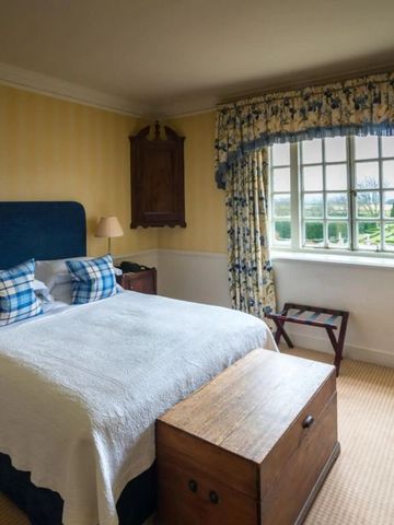 Helles Schlafzimmer mit großem Fenster und Blick in den Garten