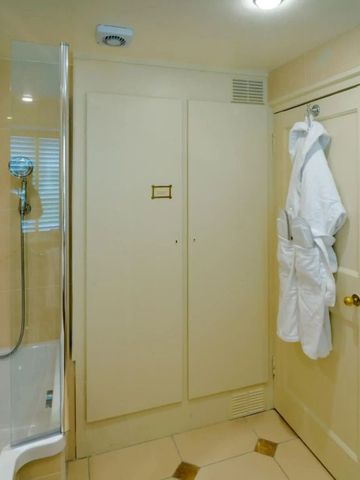 Luxuriöses Badezimmer mit flauschigen Bademänteln und moderner Dusche