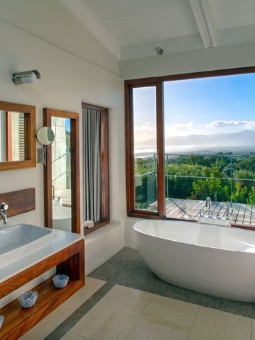 Modernes Badezimmer mit freistehender Badewanne und Panoramafenster zur Natur