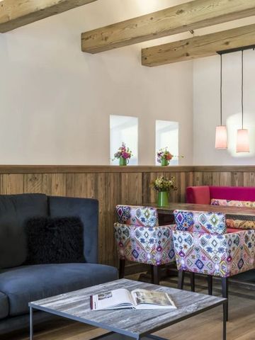 Gemütliche Sitzecke mit Holzelementen und bunten Stühlen im modernen Design