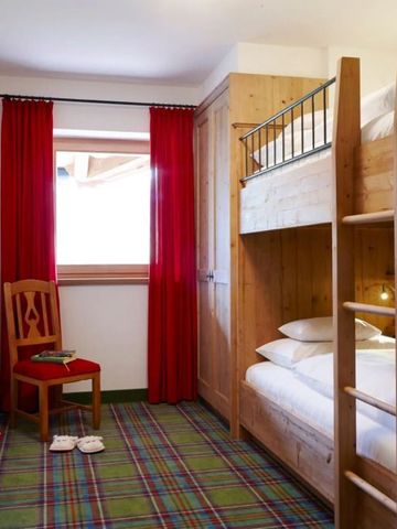 Gemütliches Zimmer mit Etagenbett und roten Vorhängen im alpinen Stil