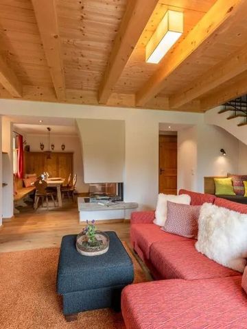 Gemütliches Wohnzimmer mit Holzbalkendecke und moderner Sitzgarnitur