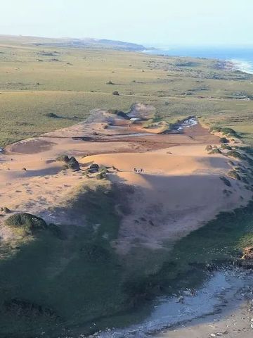 Weite Landschaft mit Sanddünen und Küstenlinie