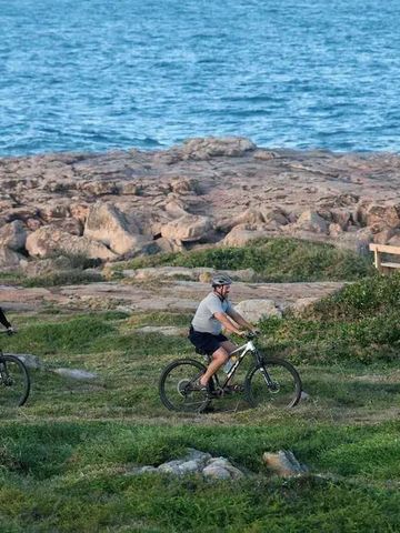 Radfahrer genießen die Küstenlandschaft am Meer bei Sonnenuntergang