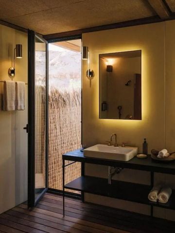 Luxuriöses Badezimmer mit Einzeltisch und leuchtendem Spiegel